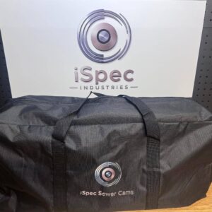 Alana stands near a black iSpec Sewer Cams bag, positioned before an iSpec Industries sign, highlighting the brand.